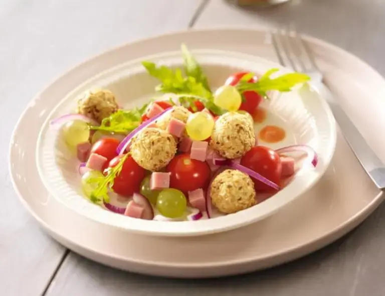 Salade raisins tomates cerises et billes de chèvre aux noisettes