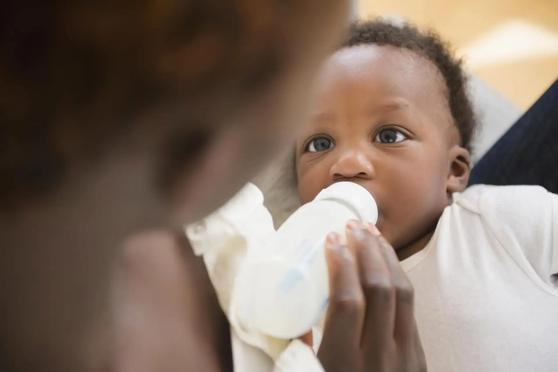 Une maman qui nourrit son bébé avec un biberon de lait Nidal