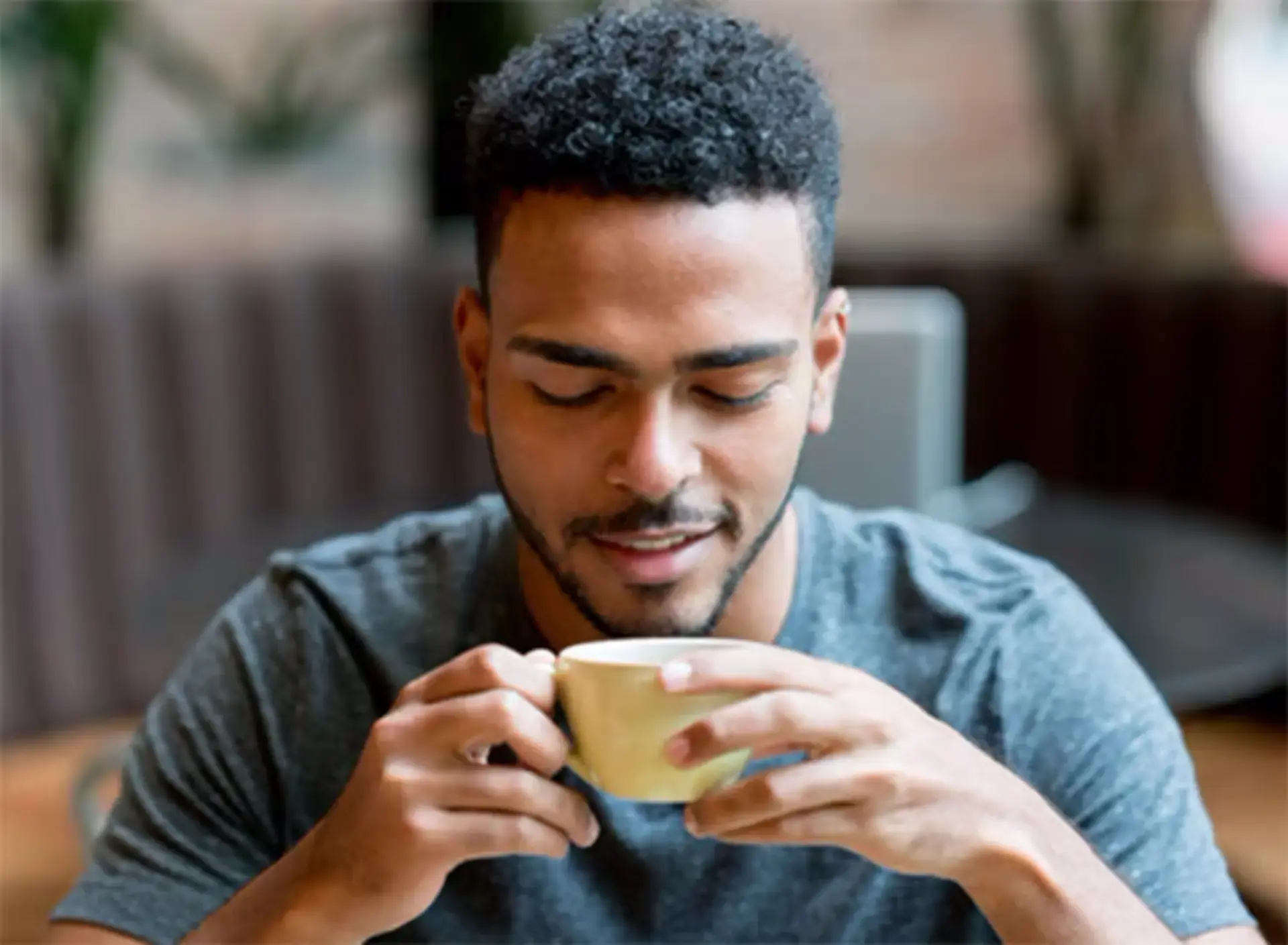 Jeune homme buvant une tasse de boisson chaude RICORÉ®