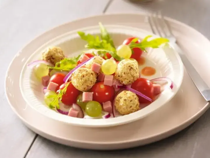 Salade raisins tomates cerises et billes de chèvre aux noisettes