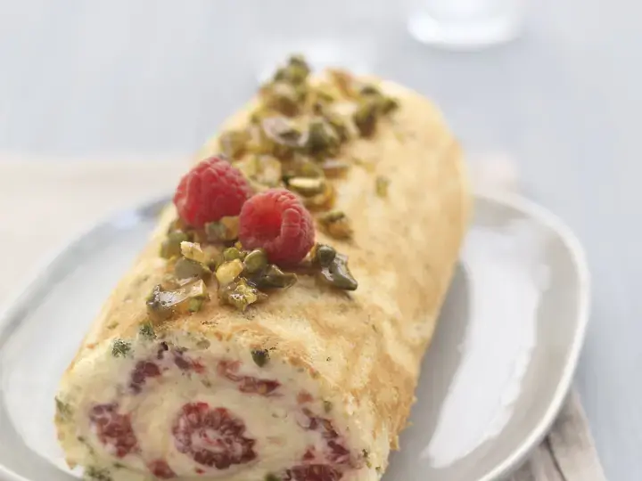 Roule aux framboises creme vanille et pistaches caramelisees