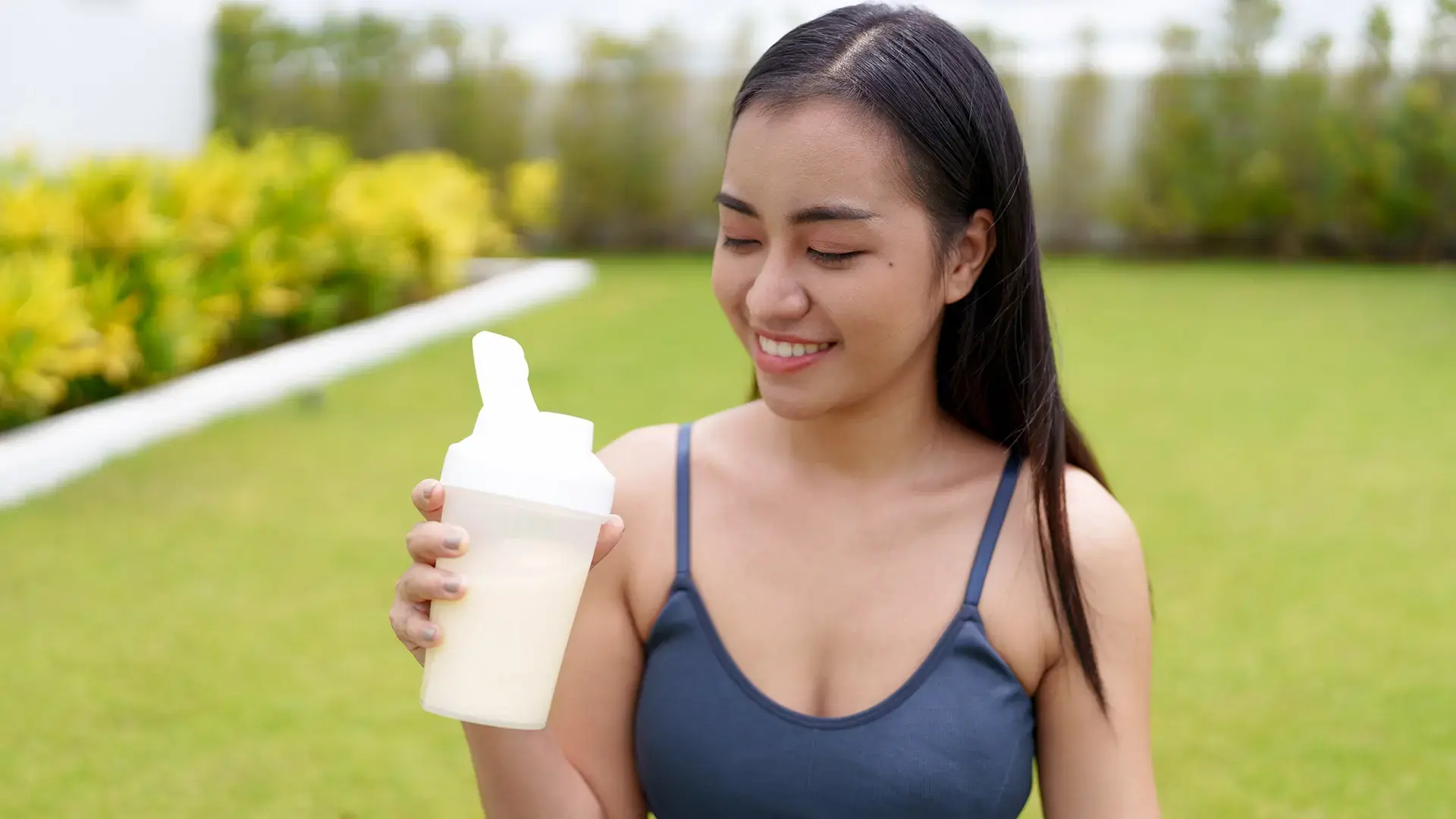 Asian woman drinking whey protein after workout