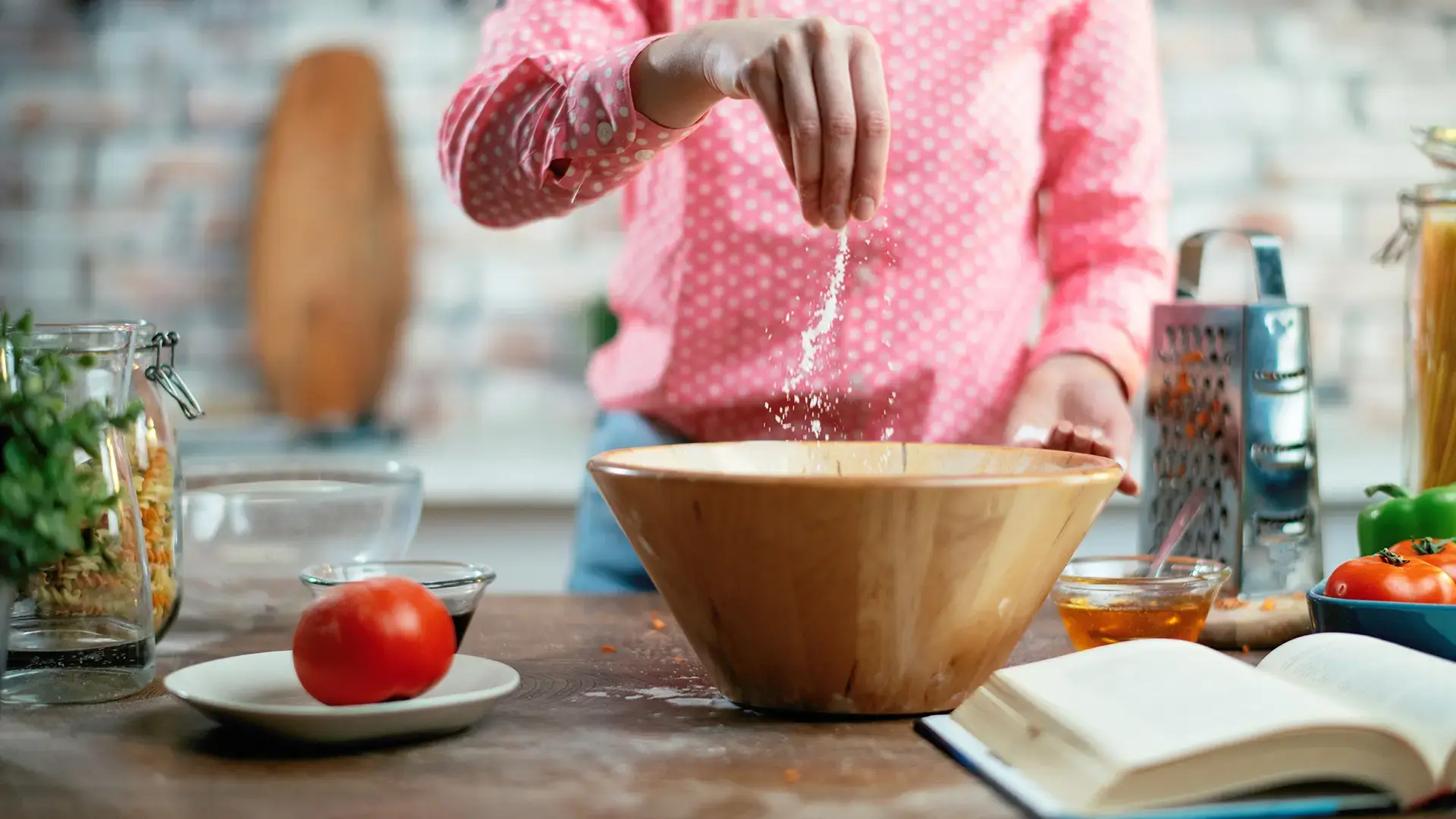 Close-up-of-female-hands-putting-salt-in-food.-Woman-cooking-in-kitchen