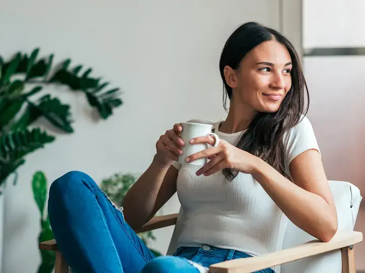 Beautiful young woman drinking tea at home